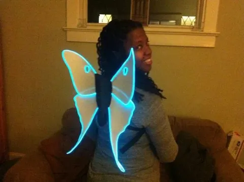 Woman wearing glowing costume luna moth wings