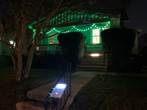 A house glowing with green holiday lights
