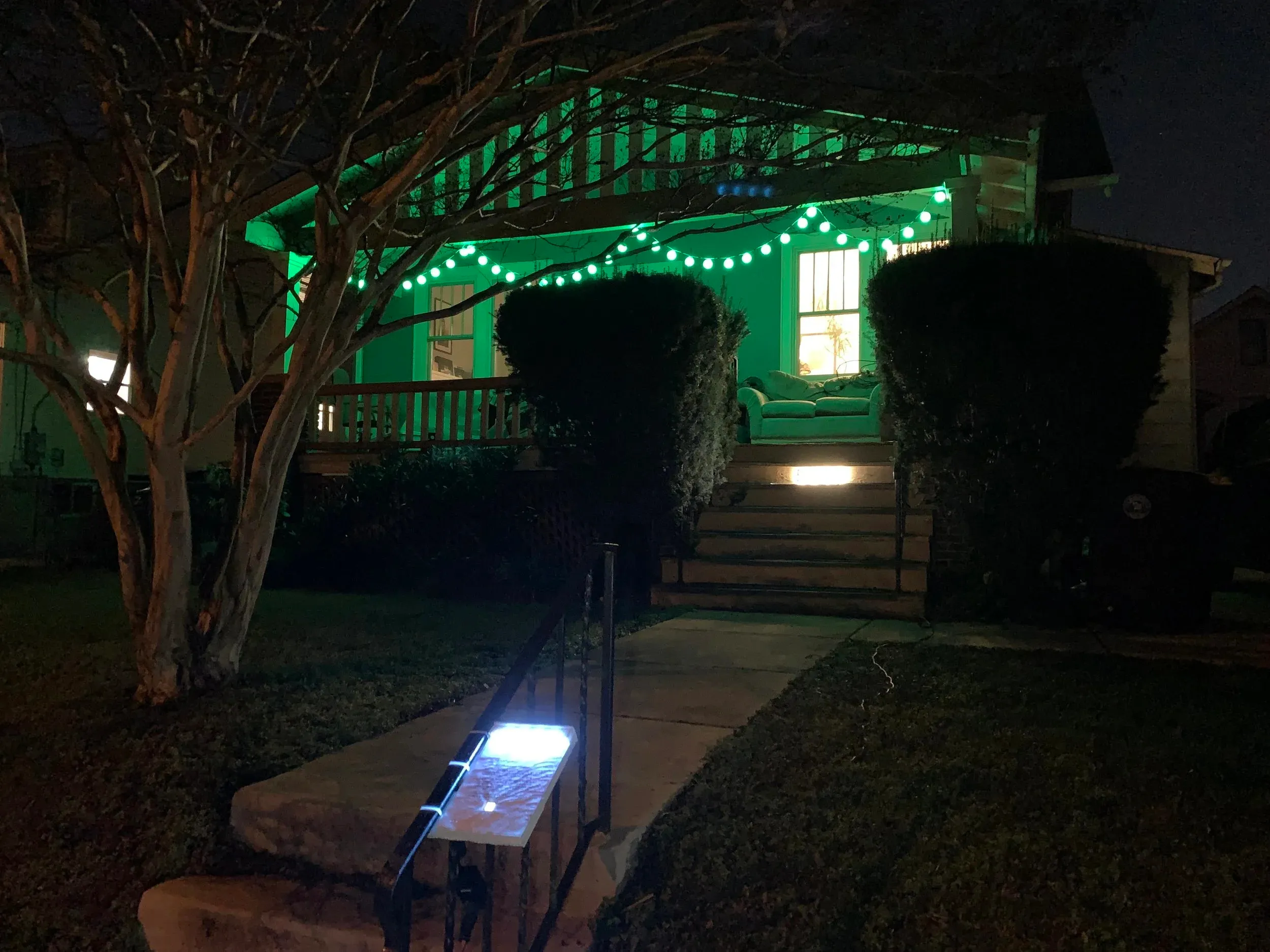 A house glowing with green holiday lights