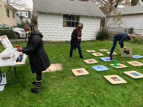 People playing a giant version of Forbidden Island in back yard