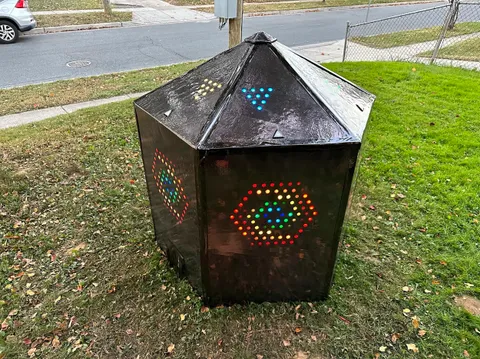 A mysterious mirrored hexagonal shard glowing in a front yard